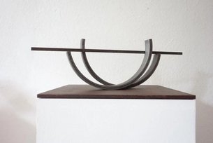 feine geschwungene Metallskulptur auf einem Podest