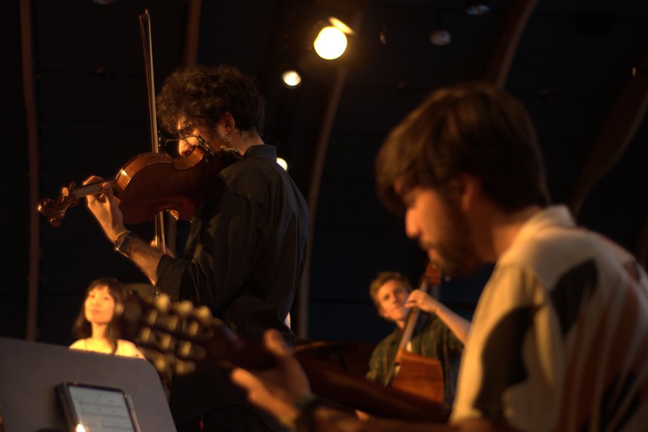 Straight Ahead Ensemble I World Music Ensemble Foto von Musizierenden im schummrigen Licht