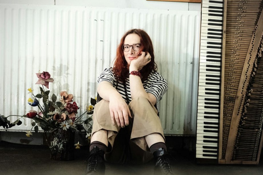 2026-01-10 Marta Winnitzki Marta Winnitzki sitzend zwischen Blumen und einem Keyboard