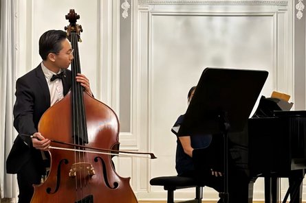 Musiker auf der Bühne, spielt Kontrabass plus Klavierbegleitung