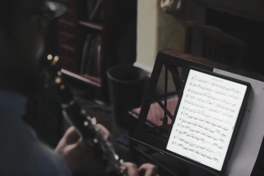 Mensch mit Klarinette und Noten-Tablet