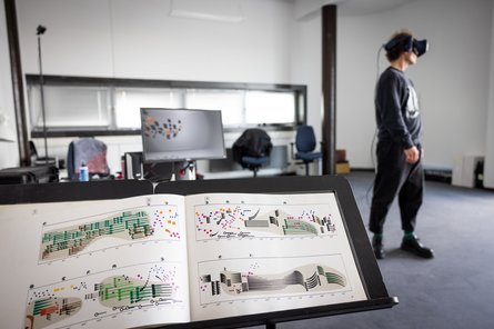 Computermusik_Foto Notenständer im Vordergrund und Person mit 3D-Bille im Hintergrund