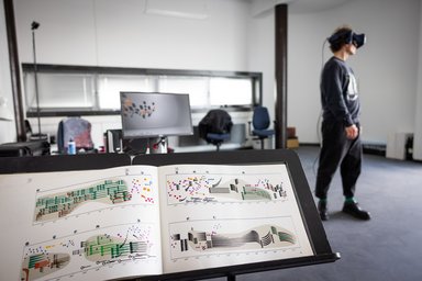 Notenständer im Vordergrund und Person mit 3D-Bille im Hintergrund