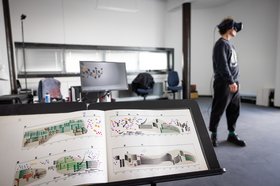 Notenständer im Vordergrund und Person mit 3D-Bille im Hintergrund