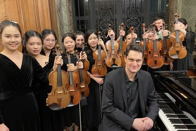 twelve violinists and one pianist with their instruments