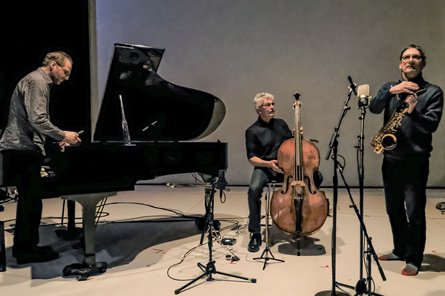 drei Personen mit Flügel, Cello und Saxophon