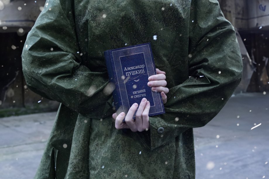 Eugen Onegin 2023 Mensch von hinten im Schnee mit Buch 'Eugen Onegin' in den Händen