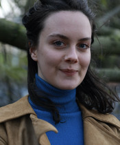 Portraitfoto von Olivia Müller-Elmau vor einem Ast