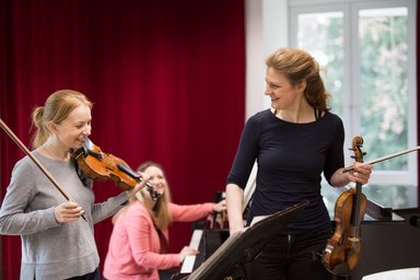 Teacher and pupil giving violin lessons