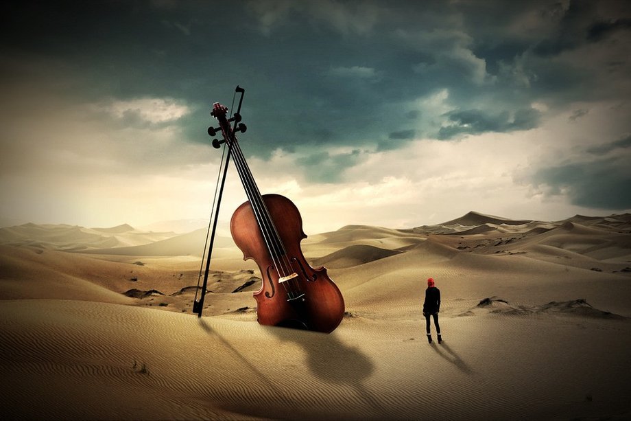 Violine im Dialog Große Violine in Wüste und Person davor guckt zu ihr auf