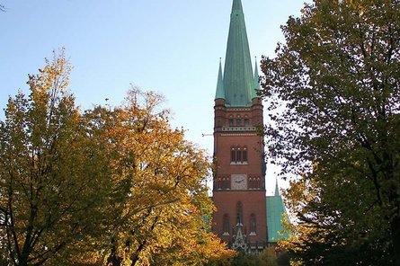 Ort.St.Johannis Harvestehude Kirche und Bäume mit blauem Himmel