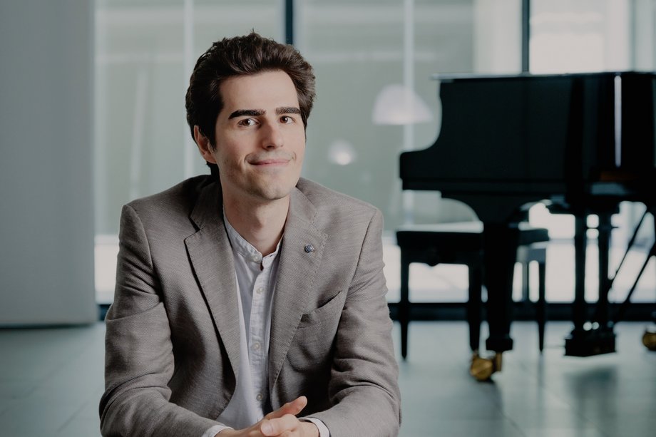 Francesco Maccarrone sitzend, im Hintergrund steht ein Flügel