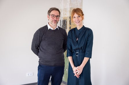 Frau und Mann stehen vor einer Säule