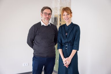 Frau und Mann stehen vor einer Säule