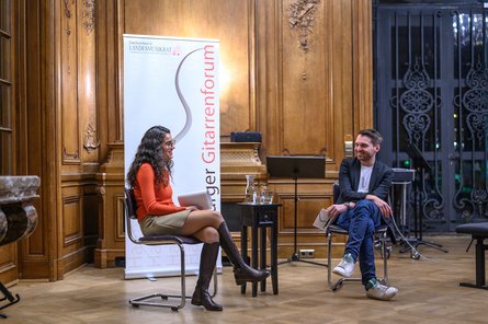 Zwei Personen auf Stühlen sitzend bei einem Interview