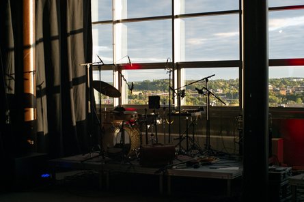ligeti zentrum mit Instrumentenaufbau drumset in einem Raum mit Fensterfront und Blick auf Häuser und Bäume von oben