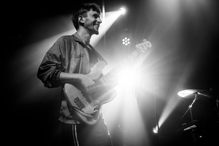 Schwarz/weiß Foto von unten von einem Mann, der Bass spielt