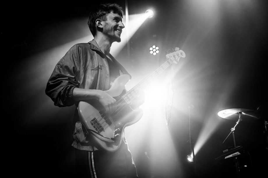 Schwarz/weiß Foto von unten von einem Mann, der Bass spielt