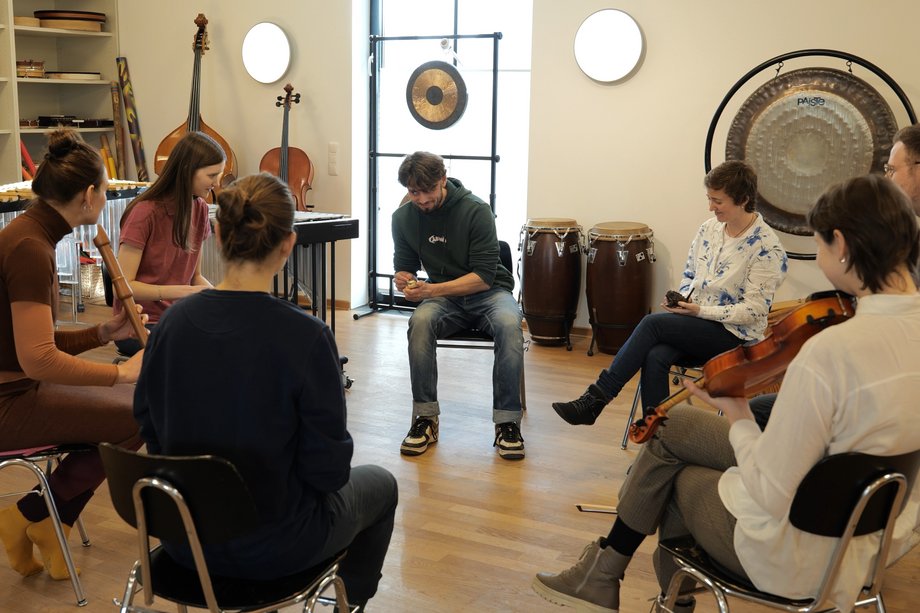 50 Jahre Musiktherapie Gruppe Studierender im Kreis mit Instrumenten
