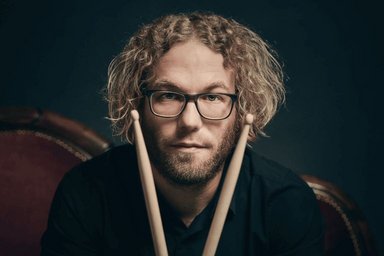 Porträt von Tobias Frohnhöfer mit Drumsticks