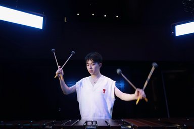 Person on drums, dark background