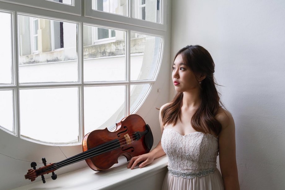 Sarah Eunji Shim at the window, her viola lying on the windowsill