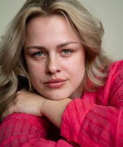 Portrait photo of Anouk Piwek Portrait photo of a blonde woman with a red sweater.