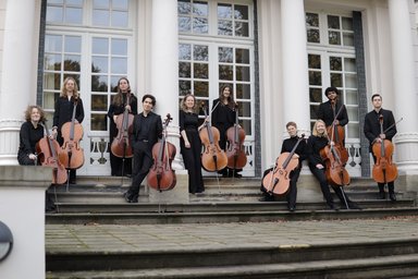 Musicians of the Cello Manifesto Ensemble with cellos standing on a staircase