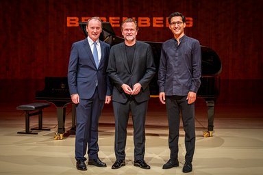 Berenberg-Preis 2025 Three men stand on a stage in front of a black grand piano