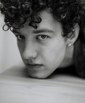 Portrait photo of Kaspar Jöhnk Black and white photo of a man with curly hair.