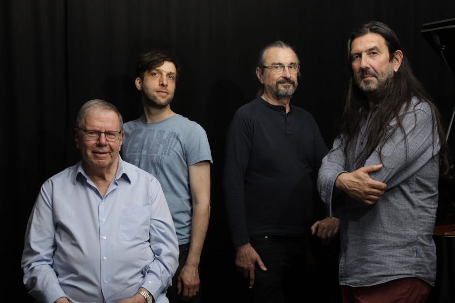 2025-09-19 Eric Plandé Unit Gruppenfoto von vier Männern vor einem schwarzem Hintergrund