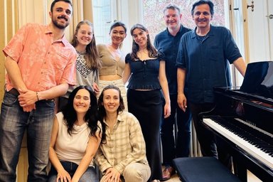 A group of people next to a piano